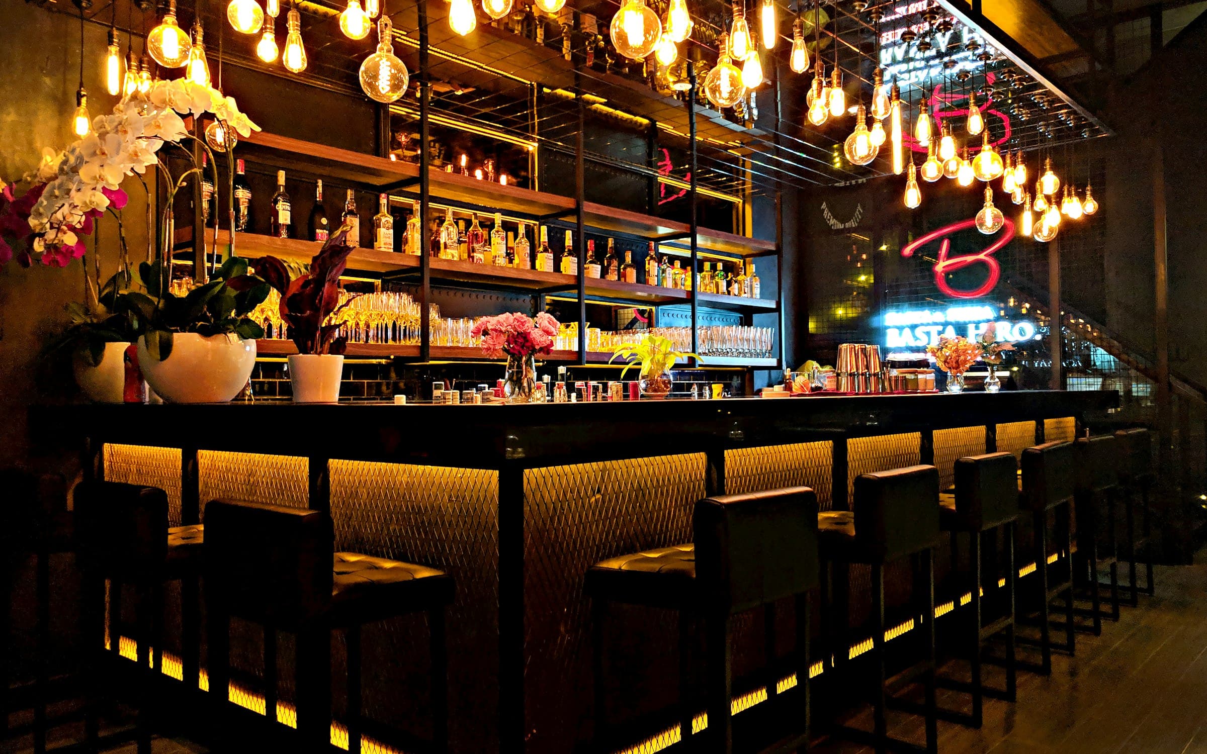 Warmly lit restaurant bar counter set for evening service, the kind of hospitality room built for live music