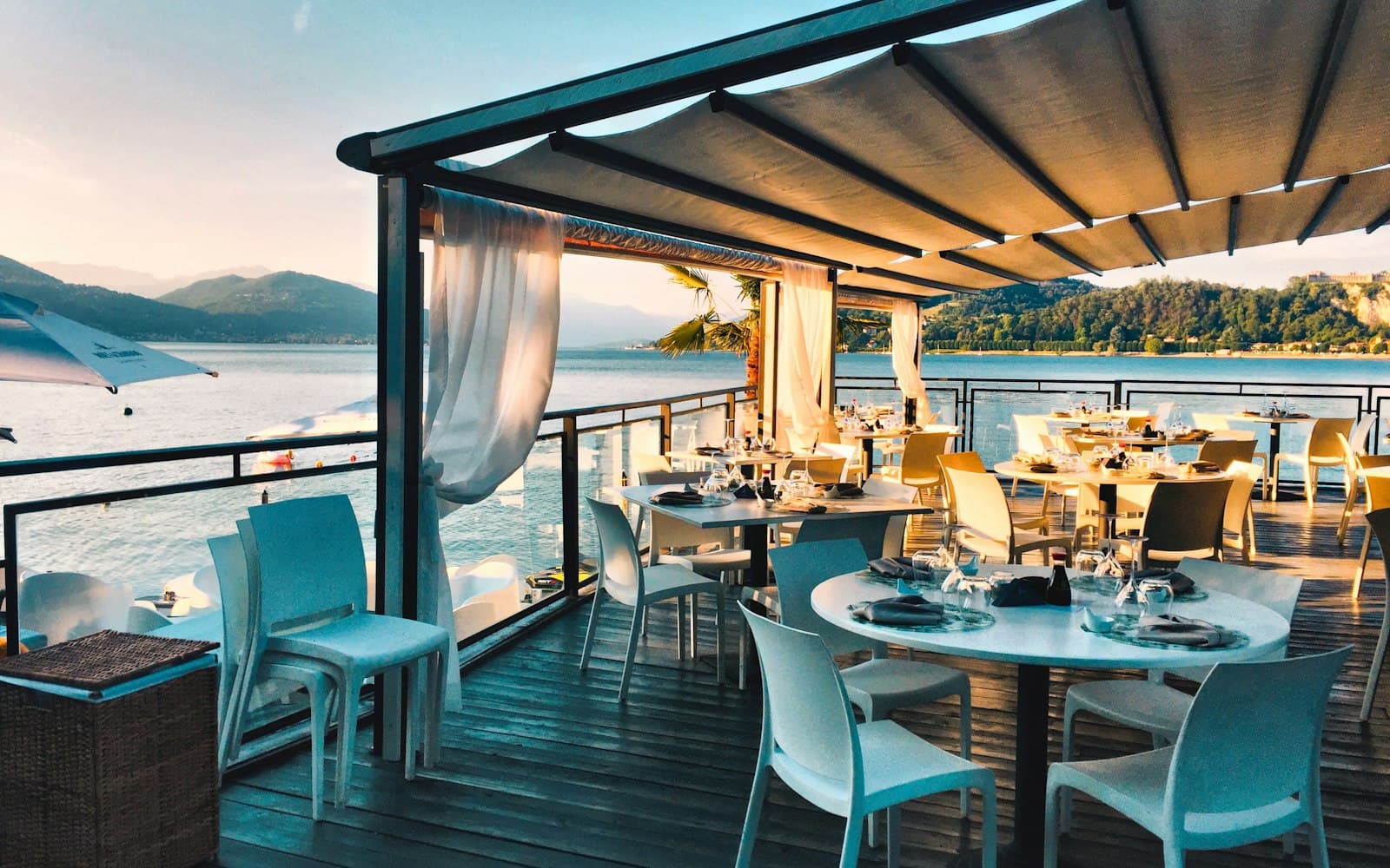 Waterfront restaurant patio with tables set at sunset, a prime setting for outdoor live music programming