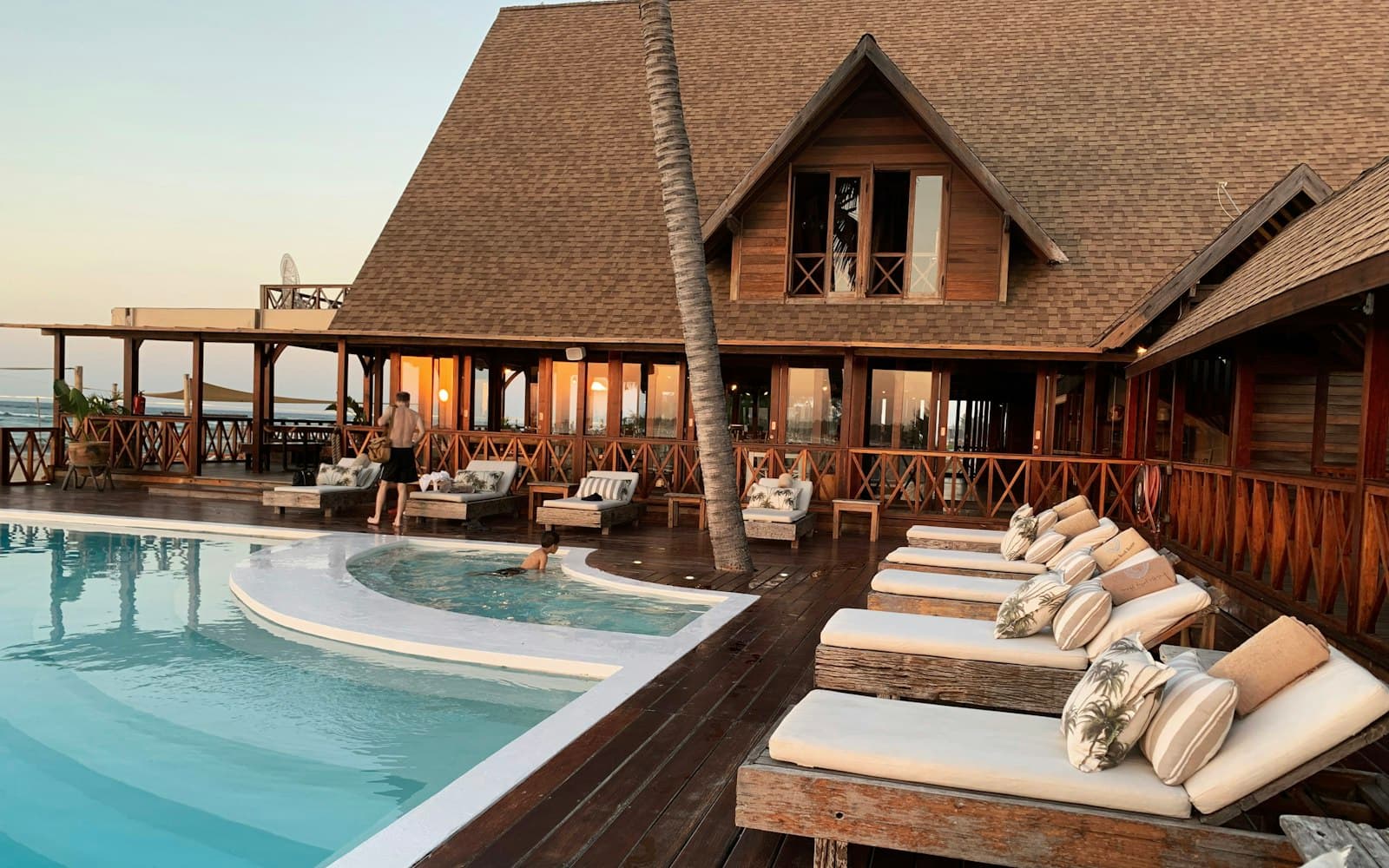 Resort pool deck at dusk with loungers and palms, a hospitality zone suited to dayparted live music and curated playlists