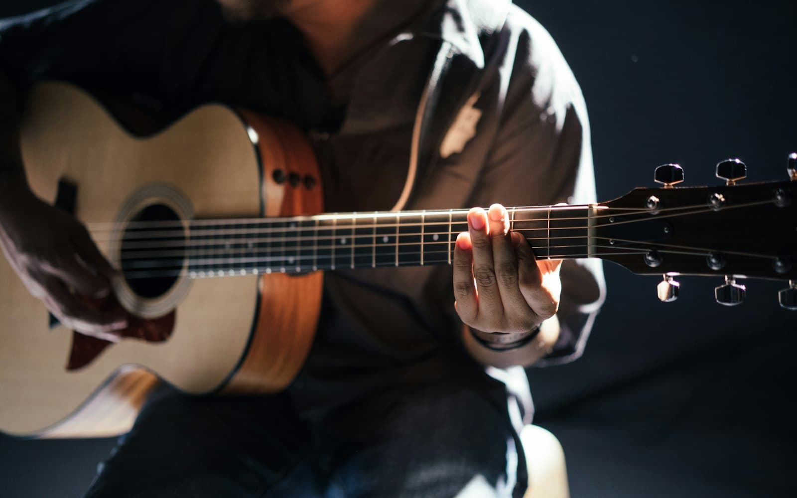 Solo acoustic guitarist performing a set, a common live music format for restaurant dining rooms and patios