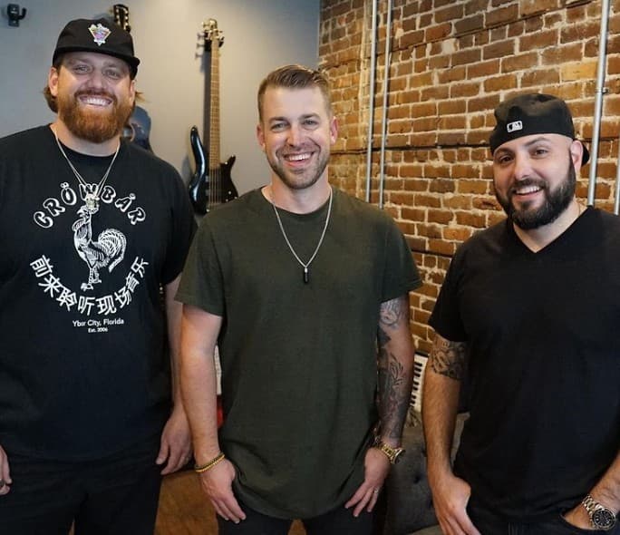 The Music Bureau co‑founders Cliff Brown, Aaron LeSage, and Dann Druen photographed inside their Historic Ybor City studio