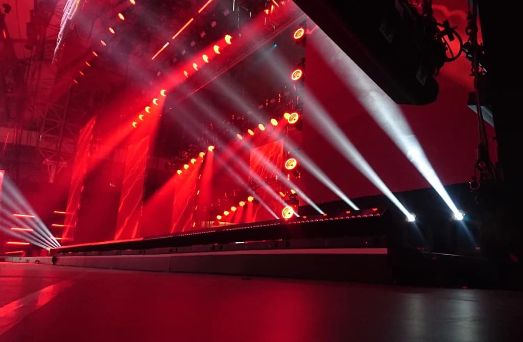 Stage lighting beams cutting through atmospheric haze at a Tampa Bay live event